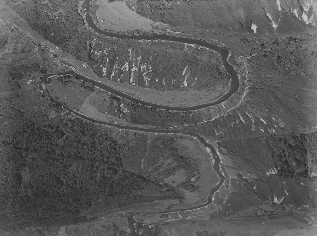 Vista aérea de um rio que desenha curvas em S pela paisagem.